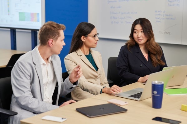 Image of Thunderbird students talking in a classroom.
