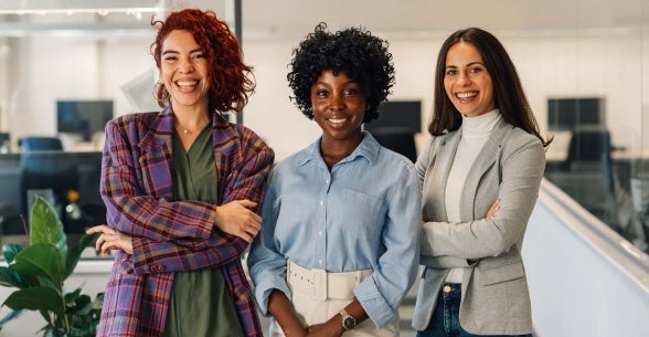 Three business women pose in their office