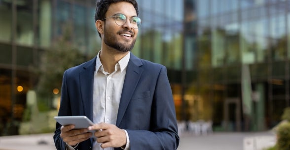 Image of a business man in a suit with a tablet.